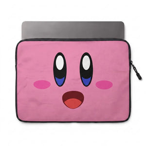 A pink laptop sleeve featuring a cartoon face inspired by Kirby, with large black and white eyes, blue under-eye details, pink cheeks, and an open red mouth. A gray laptop is partially visible inside the sleeve on a white background.